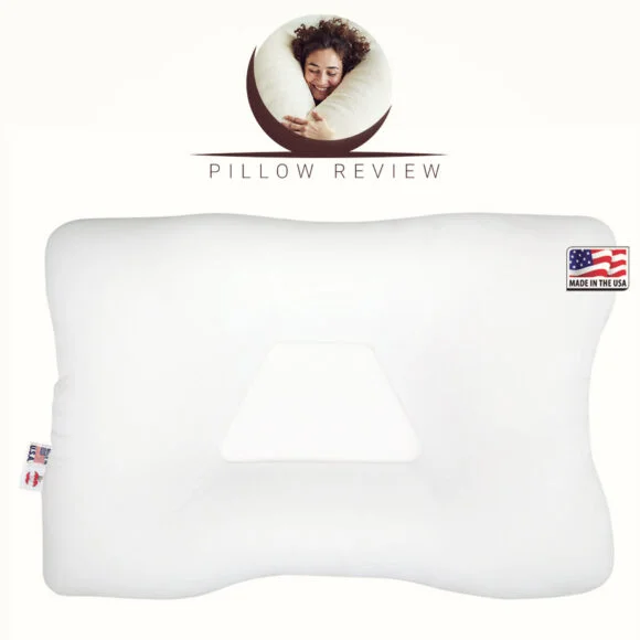 A white orthopedic pillow with an indentation in the center and a "Made in the USA" label. The top of the image features a person sleeping on a pillow with the text "Pillow Review.